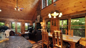 L’intérieur d’une cabane en bois comprend un coin repas, une cuisine et un espace de vie.