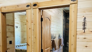 A wooden interior with a bed, a bathroom, and a wardrobe.
