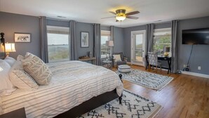 A bedroom with a large bed, a ceiling fan, a desk, and a TV. - Spectacular Estate with Breathtaking Views (Banner Elk)