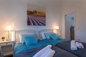 A hotel room with two beds, each with a headboard, and a painting of a field above them. There are two bedside tables with lamps and a small plant on one. - Villa 2095/39179 (Istria - Klarići), 13000m from the beach (Klarići)