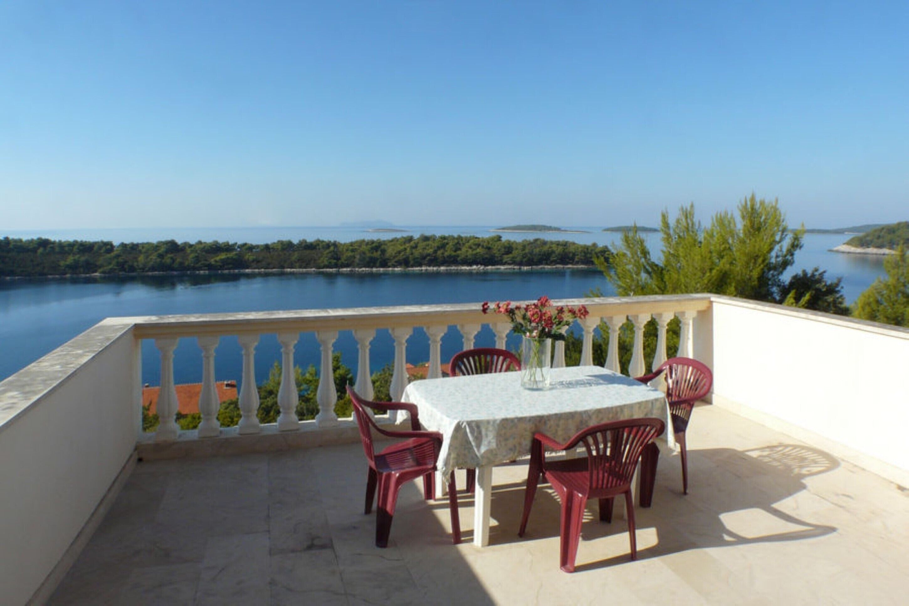 Una terrazza con tavolo e sedie affacciata su un corso d'acqua.