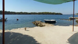A beach with boats docked near the shore and a clear view of the water.