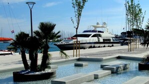 A marina with yachts docked, a pool area with concrete steps, and palm trees. - Big 80 m2 apt With Balcony in the Heart of Split (Split)