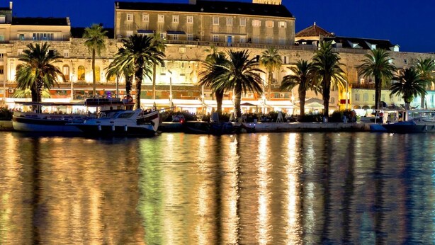 A waterfront area with boats docked, a large building with classical architecture, and palm trees lining the promenade. - Big 80 m2 apt With Balcony in the Heart of Split (Split)