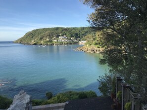A coastal view with a clear sky, calm sea, and a hillside with buildings. - Seaside 2-bed, Sleeps 4, Parking & Pet Friendly (Salcombe)