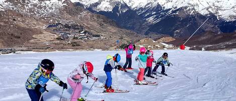Un grupo de esquiadores en una pendiente nevada con una montaña al fondo.