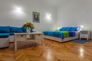 A modern room with a sofa, a bed, a small table, and a nightstand. - Classy Apartment in the Center of Split (Split)