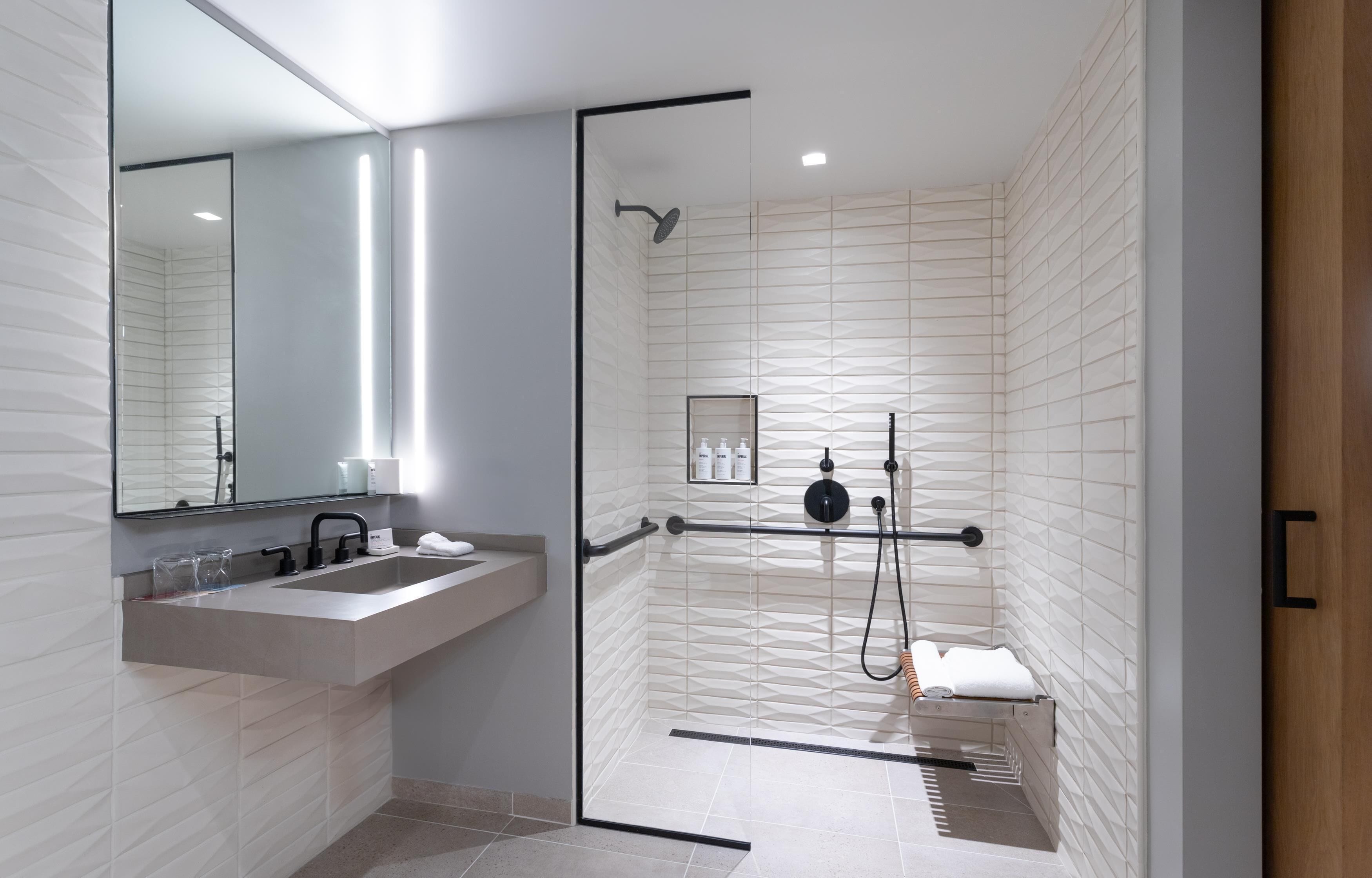 Une salle de bain moderne avec une douche à parois de verre, un meuble-lavabo et un miroir.