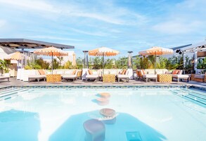 Una piscina al aire libre, sillones reclinables de piscina