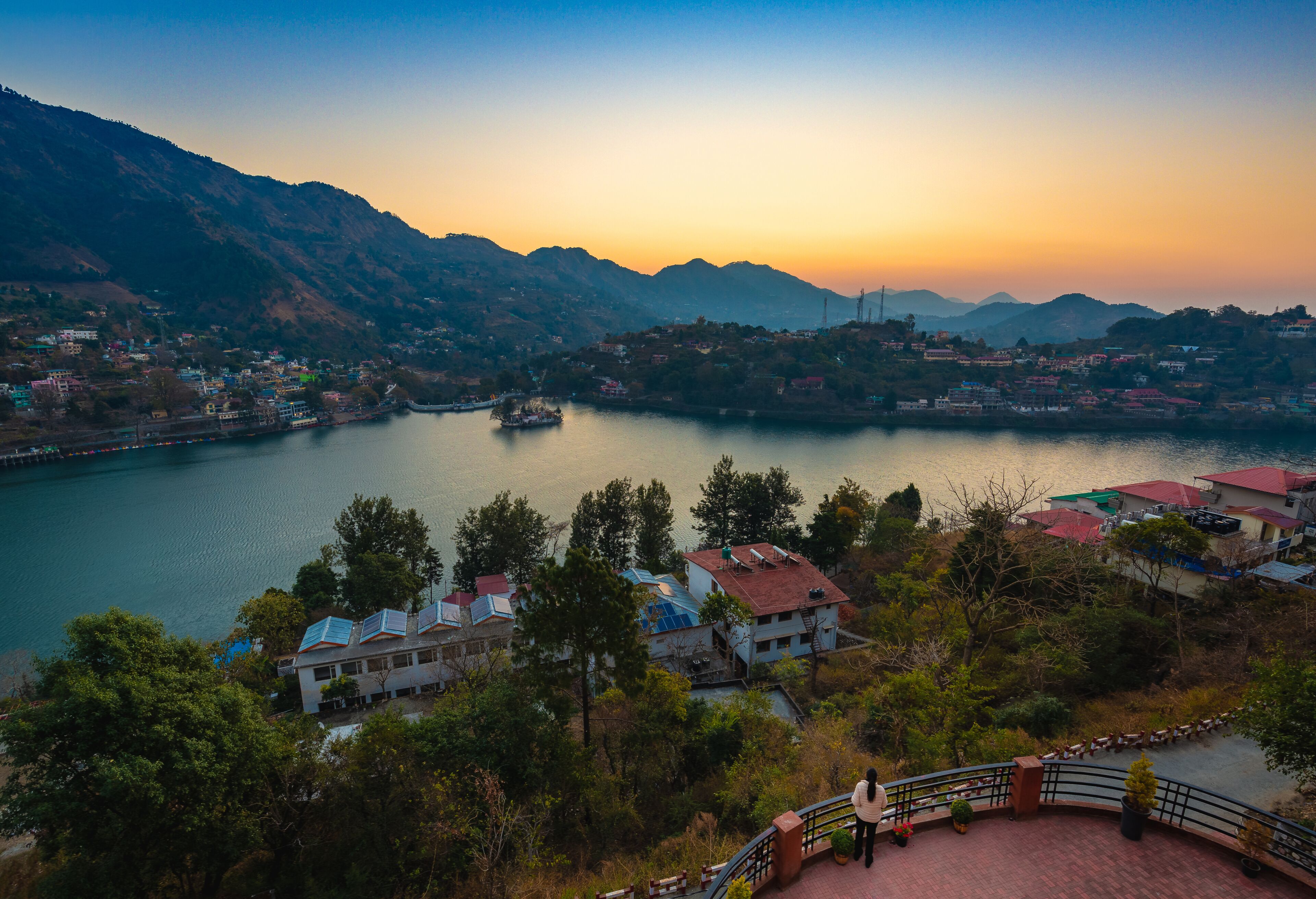 Una vista panorámica de un pueblo junto al lago, con edificios y montañas al fondo.