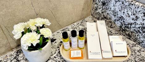 A bathroom counter with a potted plant, toiletries, and a shower cap.