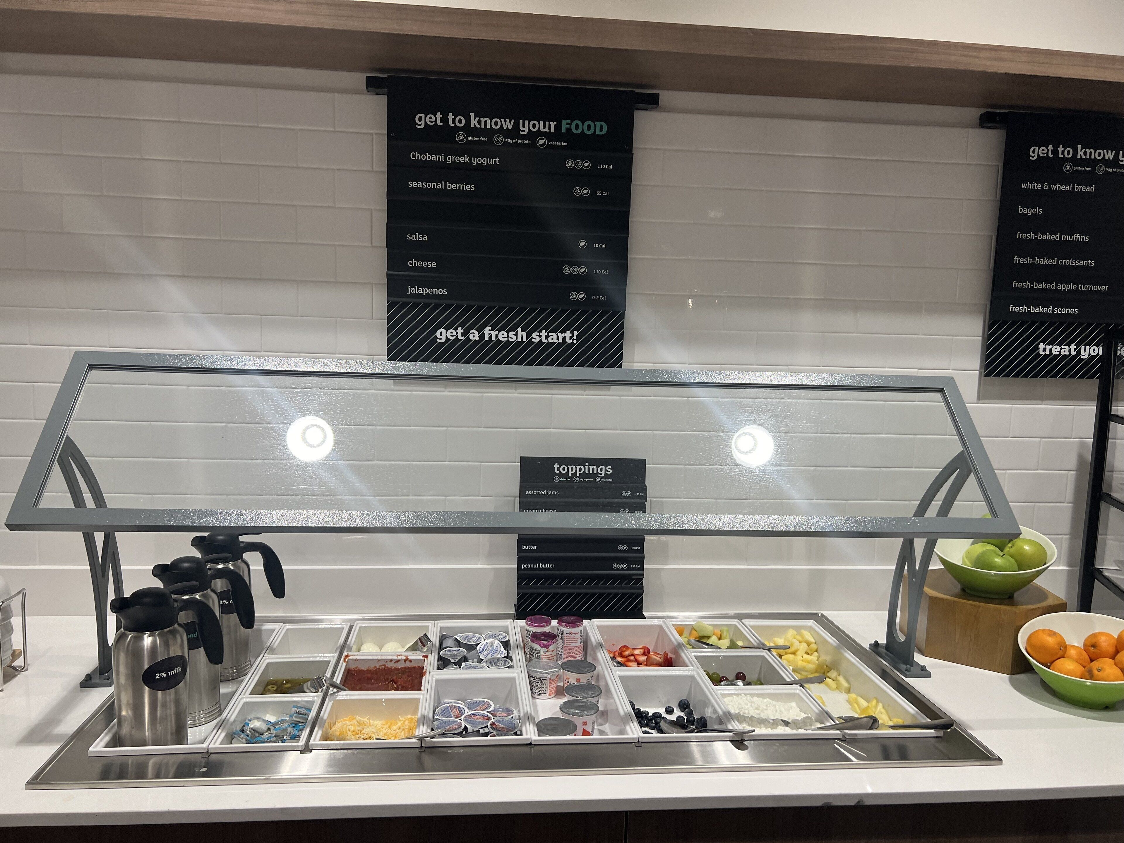 A buffet area with labeled food options and a sign indicating 'get to know your food'.