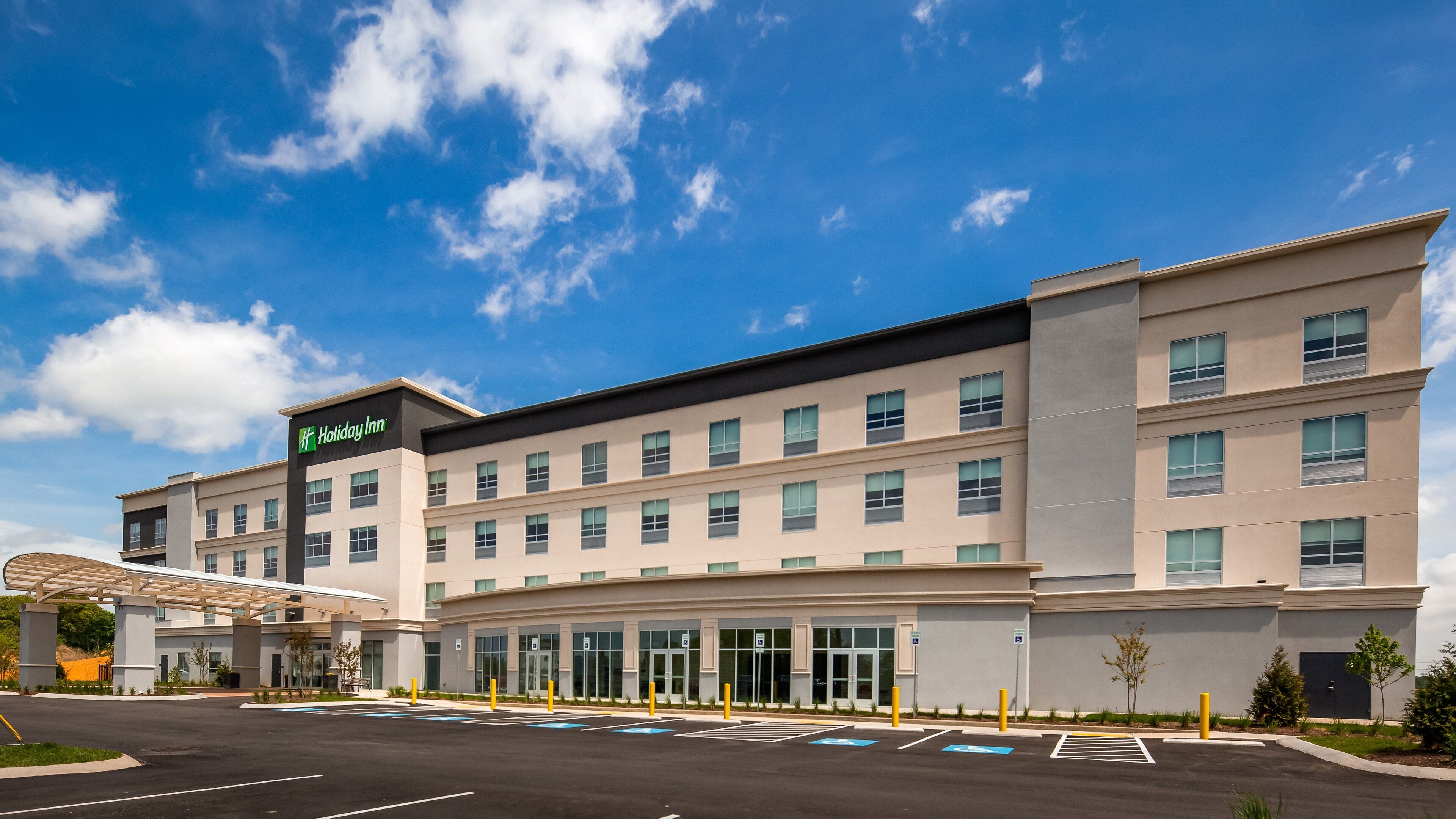 Un hôtel Holiday Inn au design moderne, avec plusieurs étages et une entrée abritée.