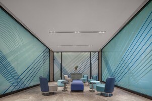 Un interior moderno con una zona de estar, una mesa central y una planta decorativa.