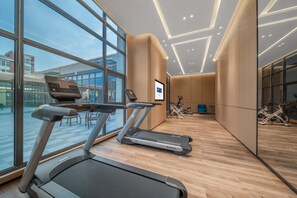 A modern gym with treadmills, a mirrored wall, and large windows. - Holiday Inn Express Yixing (Wuxi)