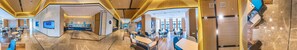 A modern hotel lobby with a central reception desk, seating areas, and a view of the dining area. - Holiday Inn Express Yixing (Wuxi)