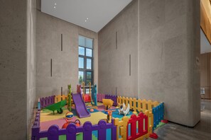 A play area with a slide, soft play equipment, and a fenced play zone. - Holiday Inn Express Yixing (Wuxi)