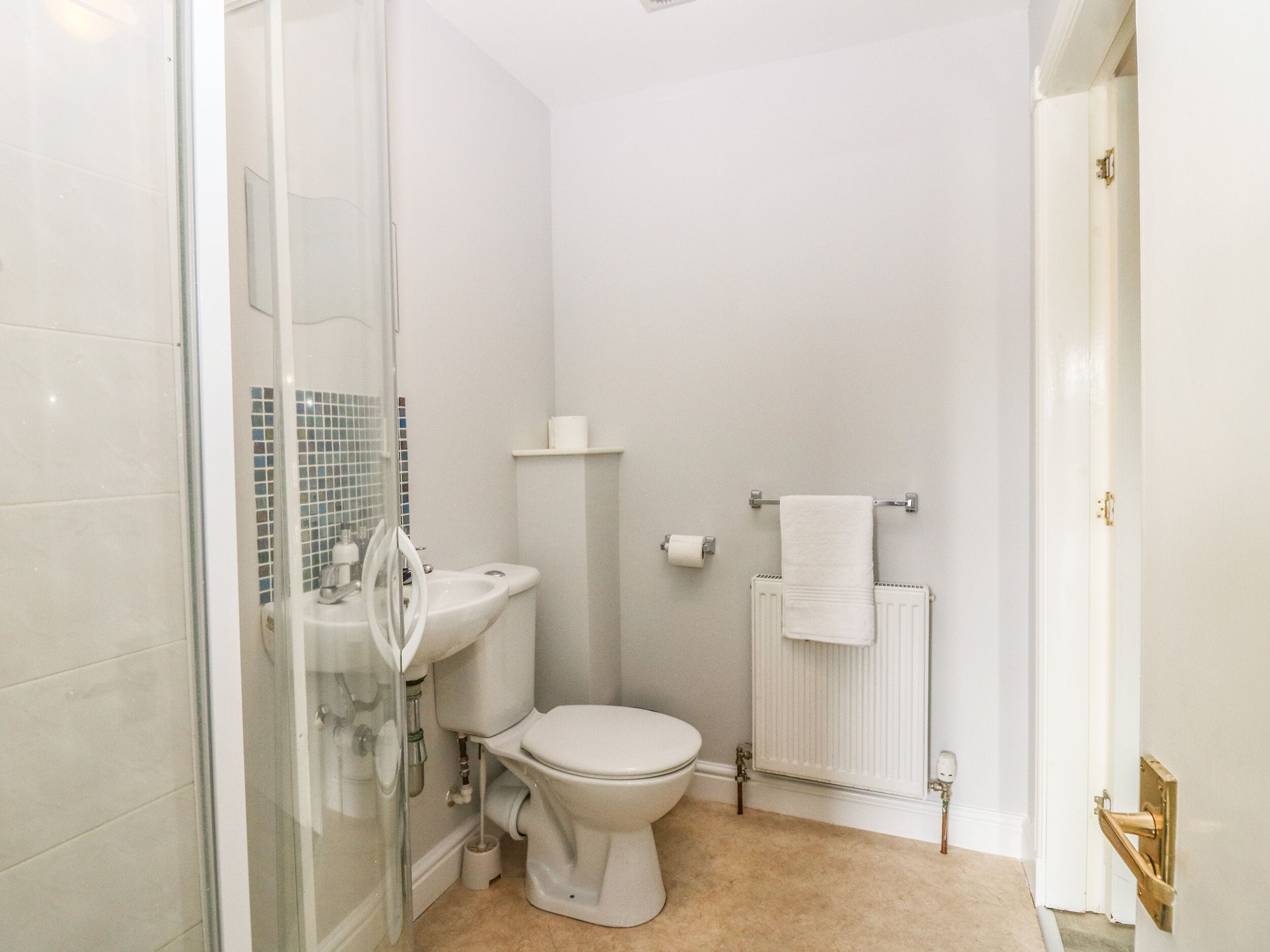 Un baño con inodoro, lavamanos y ducha.