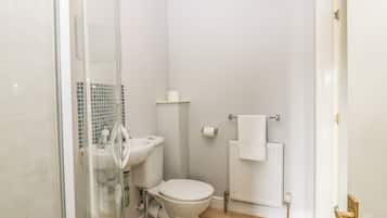 Un baño con inodoro, lavamanos y ducha.