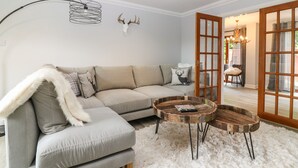 A modern living room with a sectional sofa, a round wooden coffee table, and a fluffy white rug. - Tombeck (Ballindalloch)