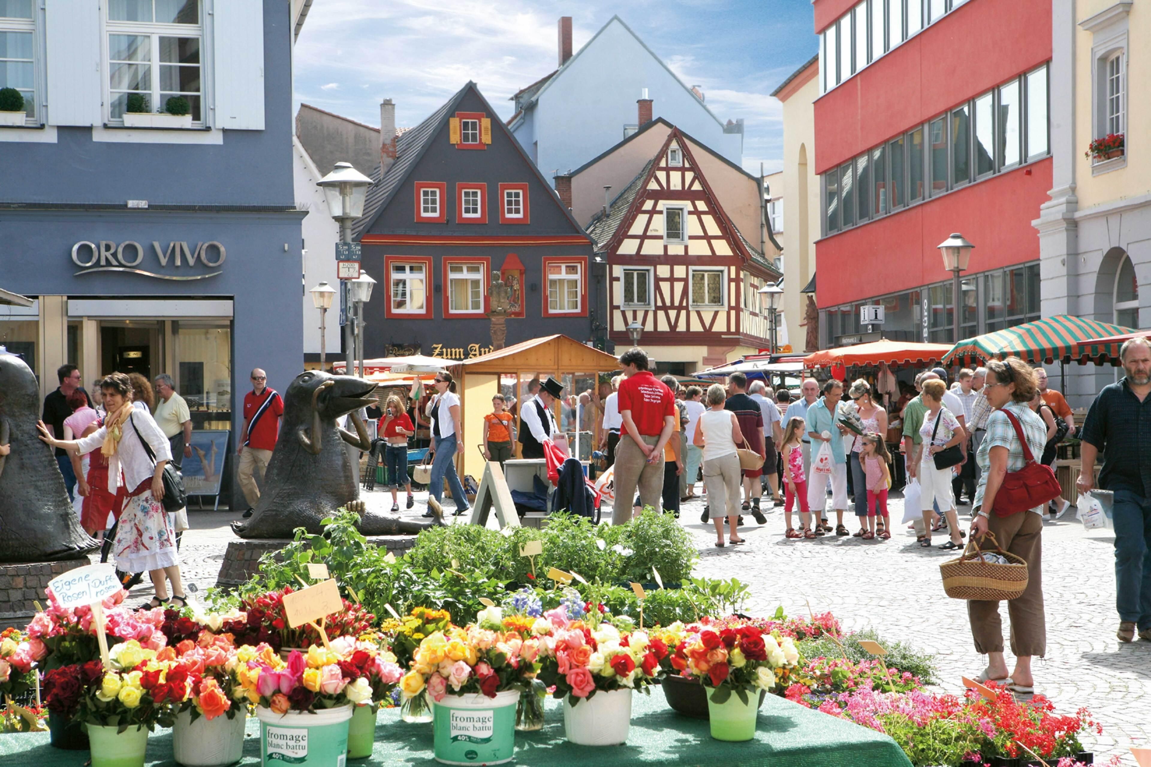 A bustling outdoor market with various stalls and people.