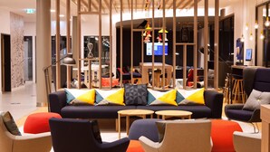 A modern lounge area with a sofa, chairs, and tables.