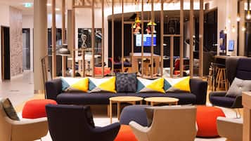 A modern lounge area with a sofa, chairs, and tables.