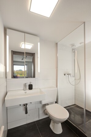 Appart'hôtel Ville | Salle de bain | Douche, sèche-cheveux, savon, papier toilette