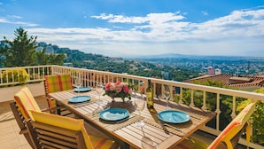 A wooden table set for dining with a view of a cityscape. - Villa Politia   Luxury Villa with a Spectacular City View (Athens)