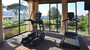 A gym with exercise equipment and large windows overlooking a scenic landscape. - La Roya (Saint-Florent)