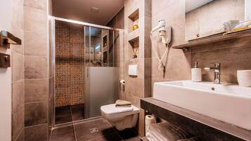 Ein modernes Badezimmer mit Duschkabine, Toilette, Waschbecken mit Spiegel und Handtuchhalter.