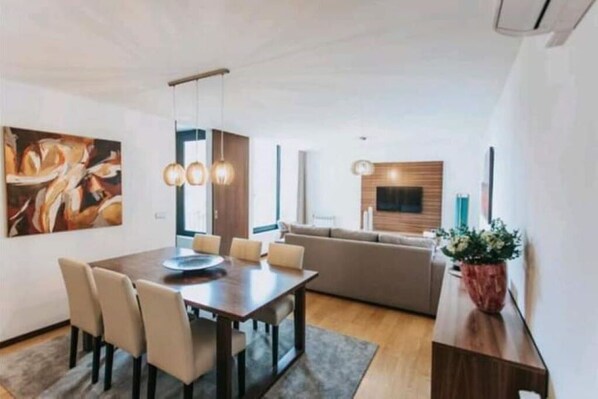 Relax in this stylish living space with a dining area, sofa, and potted plant.