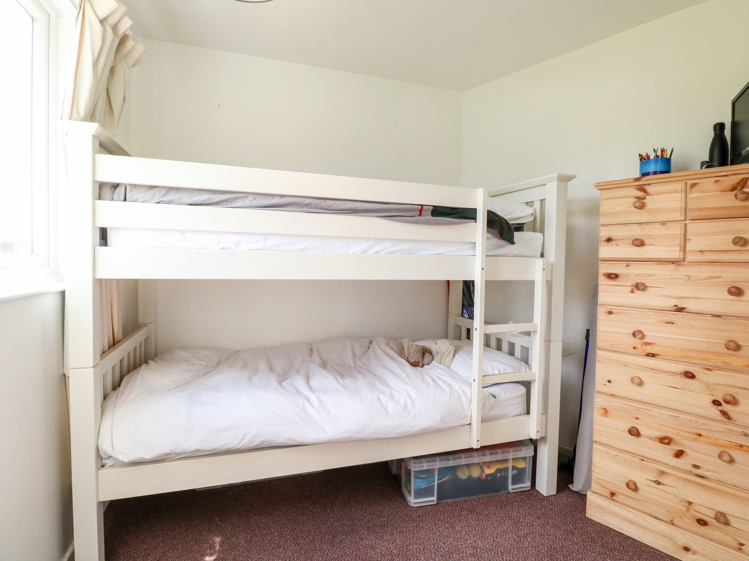 A bunk bed with a lower bunk and a storage drawer below.