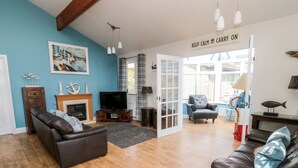 A living room with a fireplace, a television, and a sign that reads "KEEP CALM AND CARRY ON".