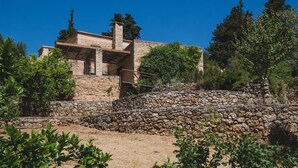 Un bâtiment en pierre avec un escalier en pierre menant à une terrasse en bois.