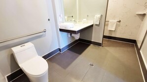 Ein modernes Badezimmer mit Toilette, Waschbecken und Duschbereich.