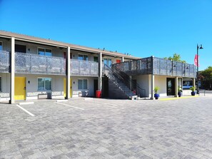 A two-story motel with a central staircase, a covered outdoor area, and a parking lot. - Signature Inn Santa Clara (Santa Clara)