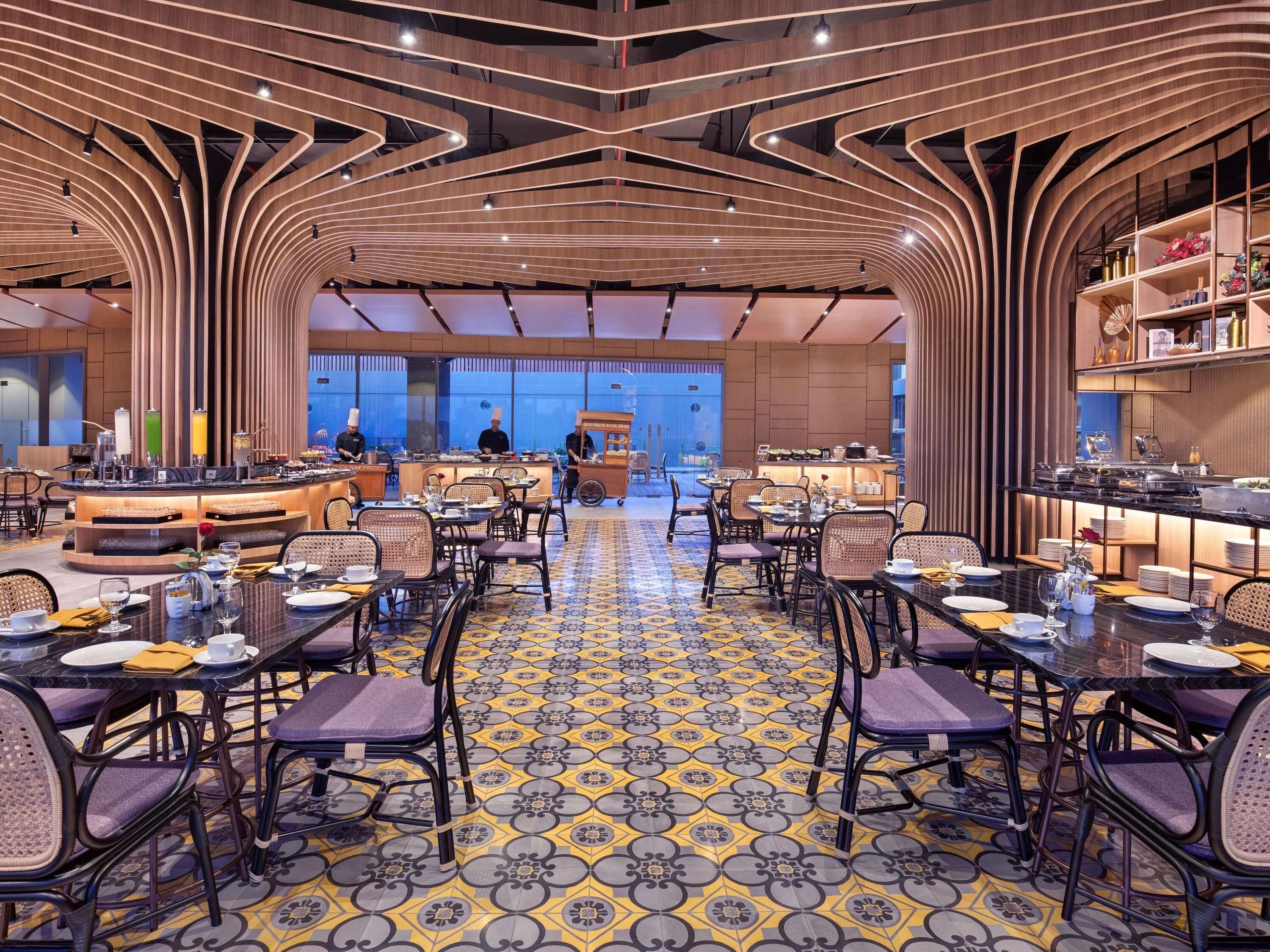 Un comedor moderno con una barra central, diferentes opciones de asientos y un suelo con diseño.