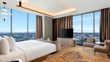 Habitación de hotel moderna con una cama grande, un televisor, un sofá y vistas a la ciudad.