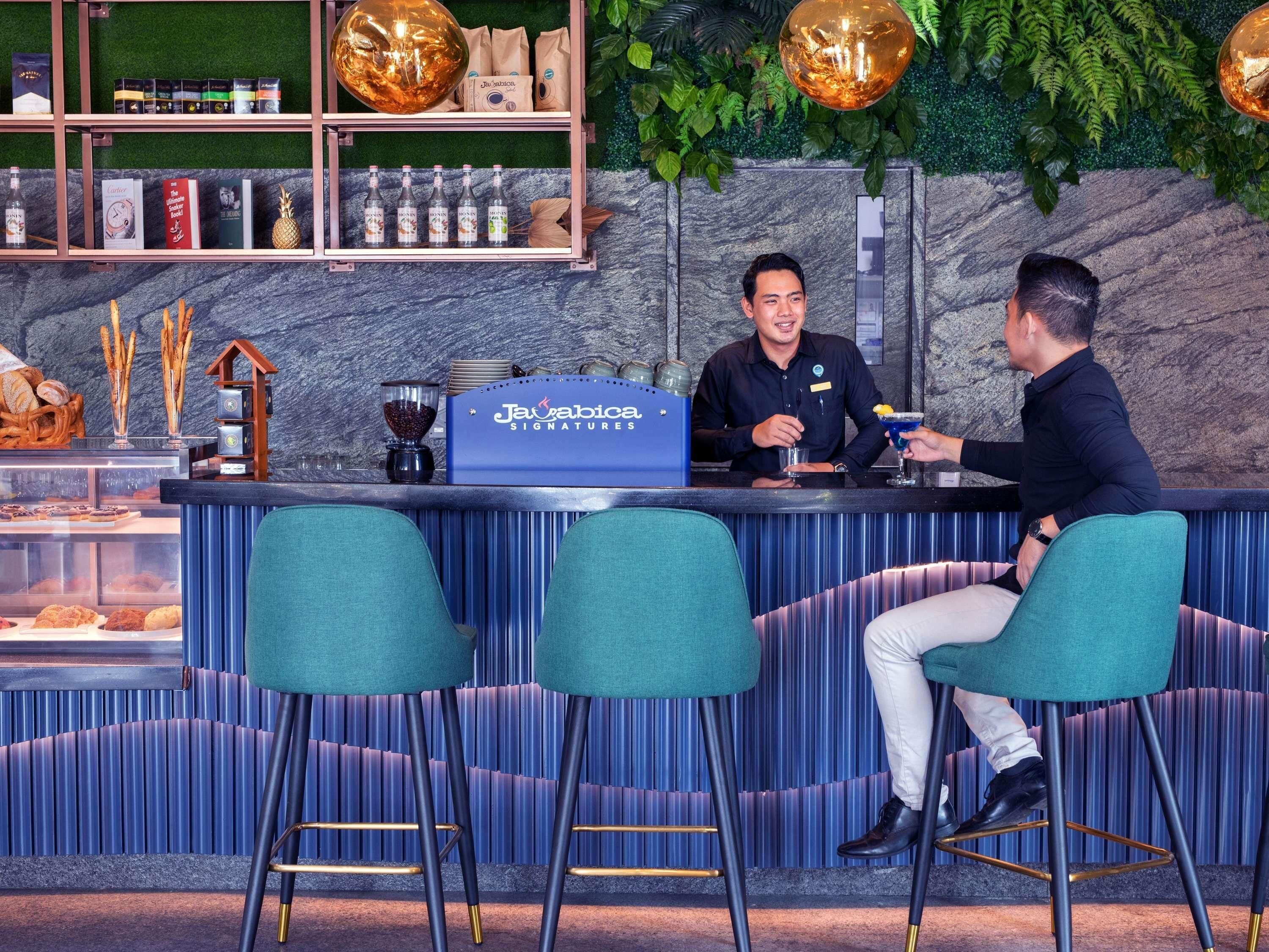 Zona de bar con mostrador, taburetes y tablero de menú.