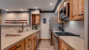 A modern kitchen with wooden cabinets, a stainless steel refrigerator, a built-in oven, and a microwave. - Esperanzas Lakeside Retreat: 3  BR, 2  BA Condominium in Tahoma, Sleeps 6 (Tahoma)