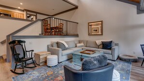 A modern living room with a grey sofa, a blue armchair, a rocking chair, and a coffee table. - Esperanzas Lakeside Retreat: 3  BR, 2  BA Condominium in Tahoma, Sleeps 6 (Tahoma)