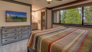 A bedroom with a bed, a ceiling fan, a window with a view of trees, a dresser, and a painting on the wall. - Esperanzas Lakeside Retreat: 3  BR, 2  BA Condominium in Tahoma, Sleeps 6 (Tahoma)