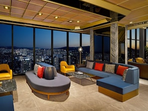 A modern interior with a large window offering a city view, a round seating area, and a bar. - Sofitel Ambassador Seoul Hotel & Serviced Residences (Seoul)
