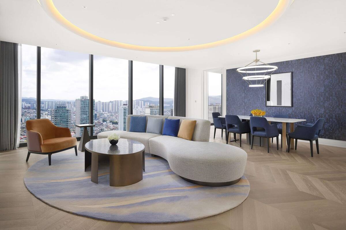 Un salon moderne comprenant un canapé, des fauteuils, une table basse et un coin repas avec une table et des chaises.
