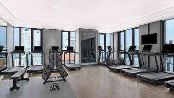 A modern gym with treadmills, elliptical machines, and weightlifting equipment.