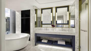 A modern bathroom with a freestanding bathtub, a vanity with dual sinks, and a large mirror.