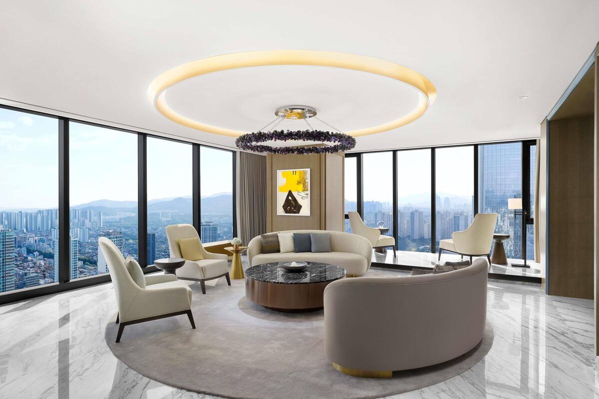 Un interior de rascacielos con una zona de estar moderna, ventanas amplias y vista panorámica de la ciudad.