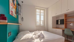 A bedroom with a bed, a window, a desk, and a television. - ALTAYA • Apt with balcony and sea view in Biarritz (Biarritz)