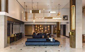 A modern lobby with a reception desk, seating area, and contemporary lighting fixtures.